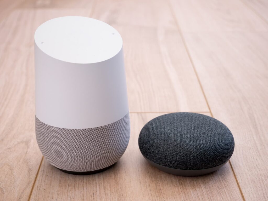 A white Google Home and black Google Home Mini